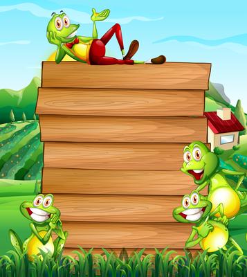 Wooden board and frogs in the field