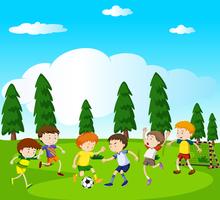 Boys playing soccer in park vector