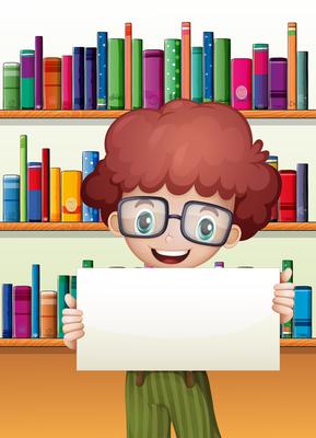 A boy holding an empty cardboard standing in front of the bookshelves