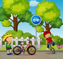 Dos niños montando bicicleta en el parque vector