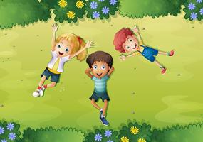 Tres niños felices en la hierba verde vector