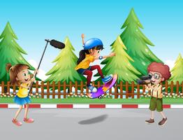 Kids shooting vdo of girl skateboarding in the park vector