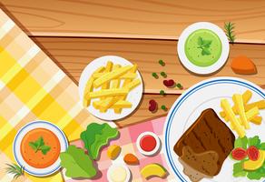 Table scene with fries and steak on the dish vector
