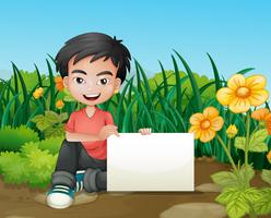 A smiling boy holding an empty signage in the garden vector