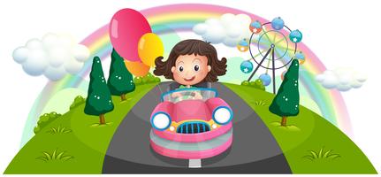 A young girl riding in a pink car with balloons