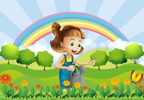 Una niña sosteniendo un aspersor en el jardín. vector