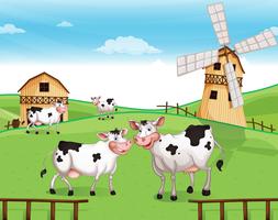 Cows at the hilltop with a windmill vector