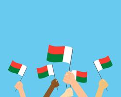 Vector illustration of hands holding Madagascar flags isolated on background 