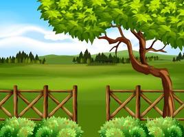 Escena de la naturaleza con campo y árbol delante de la valla vector