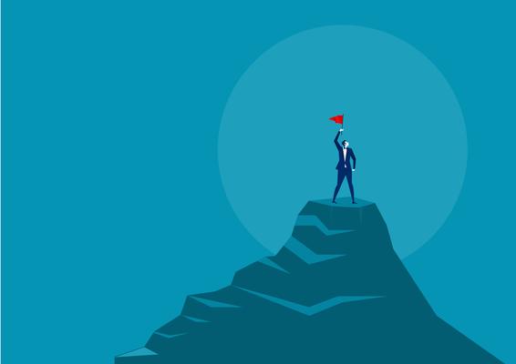 Businessman holding red flag and standing on the top of the moutain