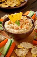 Healthy homemade hummus with vegetables, olive oil and pita chips photo