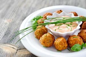Falafels on a plate with dip sauce and herbs photo