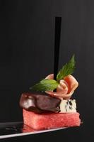 Isolated canape with bacon, watermelon and blue cheese is covered photo