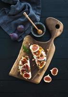 Sandwiches with ricotta, fresh figs, walnuts and honey on rustic