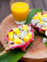 Ensalada de frutas tropicales en pitahaya, cuencos de dragón con jugo de mango.