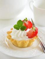 Tartlets with whipped cream and strawberries.
