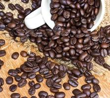 granos de café y taza sobre fondo de madera