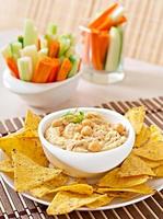 Healthy homemade hummus with vegetables, olive oil and pita chips photo