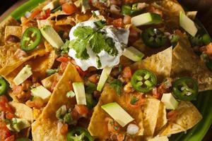 Homemade Unhealthy Nachos with Cheese and Vegetables photo