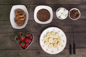 chocolates frutas y galletas en la mesa de madera foto