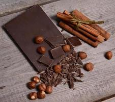 Pieces of dark chocolate on a wooden background photo