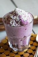 blueberry banana smoothie with coconut in a glass