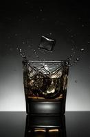 splashing whiskey with ice cubes photo