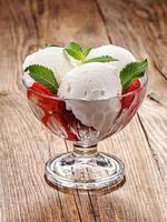 Ice cream with strawberries on an old table photo