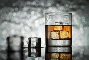 Glass with icecubes on abstract background