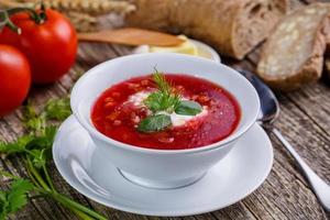 Tasty soup with bread on a wooden background. photo