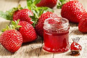 Fresh homemade strawberry jam with berries in small jars, select photo