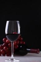 Glass of wine grapes and bottle photo