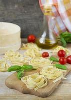 fresh homemade pasta machine pasta, basil,tomatoes on a wooden