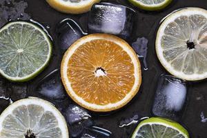 Sliced citrus fruits lemon, lime, orange, grapefruit with ice ov