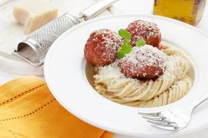 Pasta with Meatballs in tomato sauce, watercress and parmesan cheese photo