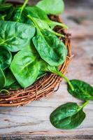 Fresh spinach on rustic wooden background photo