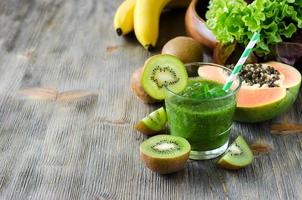 Green smoothie with kiwi, papaya and salad leaves copy space