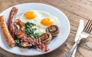 Fried eggs with bacon on the wooden table photo