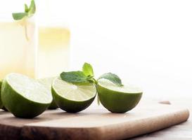 Fresh limes and lemonade on wooden background