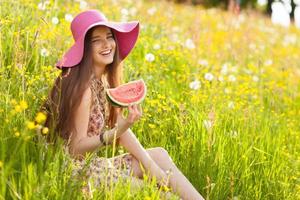 Young beautiful woman eating a watermelon