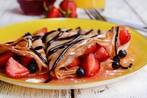 Delicious pancakes with berries on table close-up photo