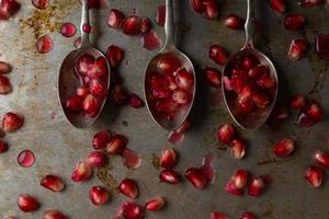 three spoons with pomegranate seeds