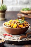 Lentil with carrot and pumpkin ragout in a wooden bowl. photo