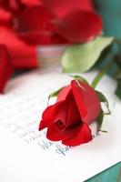 rosa roja en carta de amor foto