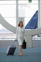 Businesswoman walking through airport terminal photo