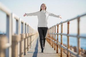 young woman with open arms walking photo