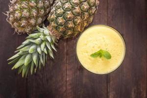 Top pineapple smoothie on wooden table photo