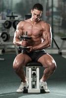 Bodybuilder Exercising Biceps With Dumbbells photo