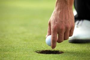 Person holding golf ball, close-up photo