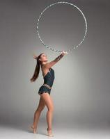 teenager doing gymnastics exercises with gymnastic hoop photo